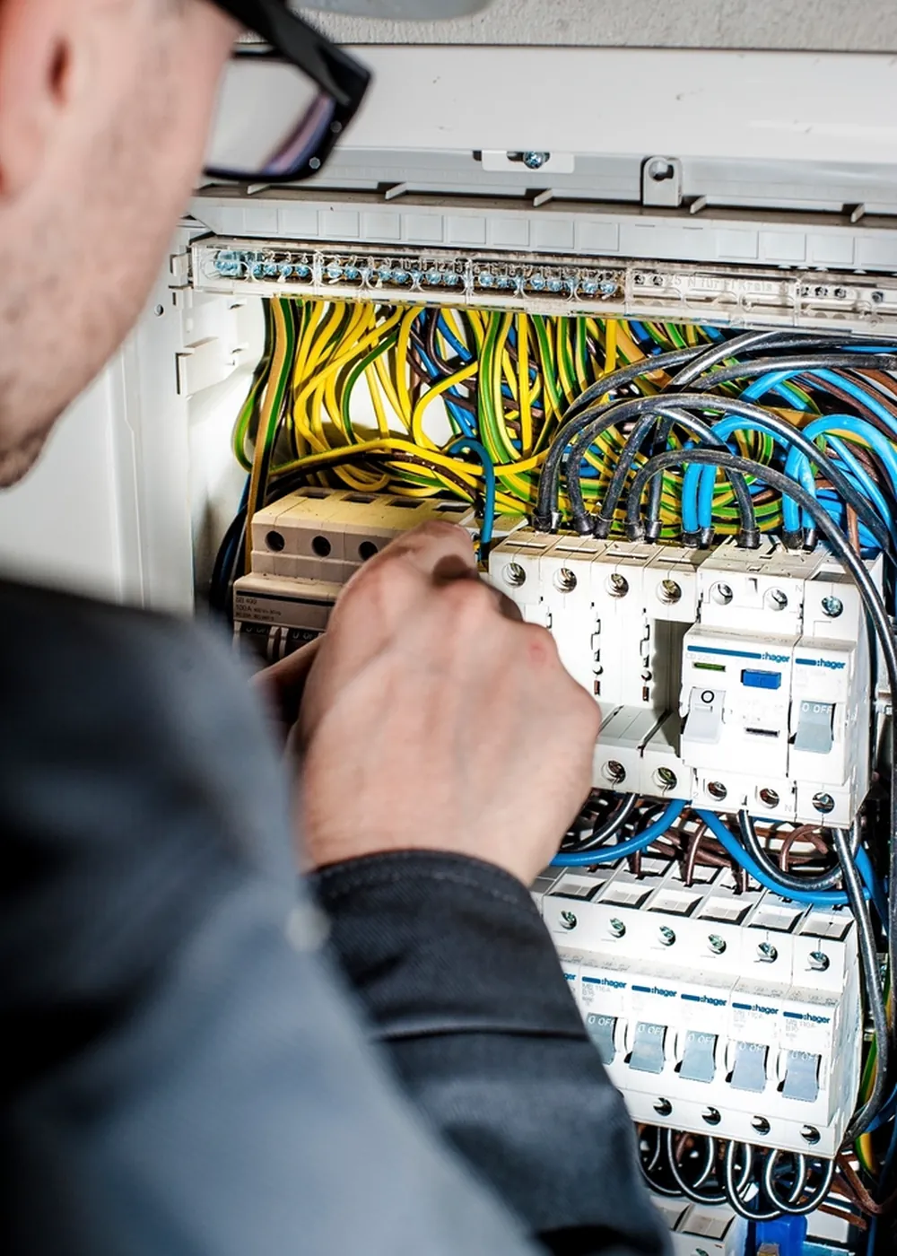 Technician working inside a power distribution panel